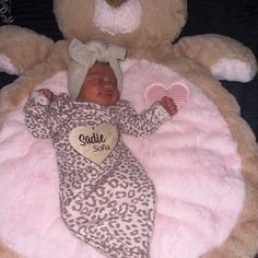 a baby is laying in a large teddy bear bed with a heart on it's chest