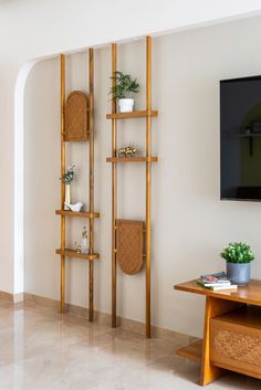 a living room with a tv and some shelves on the wall next to a table