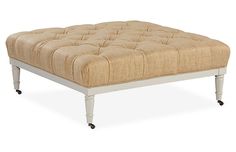 a footstool with wheels is shown on a white background and beige upholstered fabric