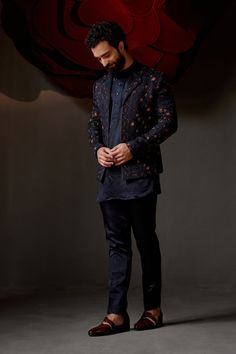 Midnight Rose Short Jacket| Jatin Malik Introducing our exquisite midnight rose short jacket, featuring a sophisticated double lapel detail. This stunning piece is hand-embroidered using the traditional zardozi technique with midnight and wine threads, creating a rich and luxurious texture. Paired with a short-length tone-on-tone kurta and tapered trousers, this ensemble perfectly balances elegance and contemporary style. Ideal for any special occasion, this outfit is a testament to impeccable craftsmanship and refined design. Included in purchase: Short Jacket, Kurta, Trousers Product Specification Color: Midnight Blue Fabric: Linen Silk Occasion: Engagement, Wedding, Bridal, Reception Style: Short Jacket, Kurta, Trousers Care: Dry Clean Work: Hand Embroidery Customization options:Can be Elegant Nehru Jacket With Resham Embroidery For Fall, Elegant Nehru Jacket With Intricate Embroidery For Fall, Long Sleeve Bandhgala With Floral Embroidery For Parties, Elegant Fall Bandhgala With Zari Work, Party Long Sleeve Bandhgala With Floral Embroidery, Festive Bandhgala With Floral Embroidery For Party, Festive Semi-formal Embroidered Outerwear, Festive Party Bandhgala With Floral Embroidery, Semi-formal Party Wear Blazer With Long Sleeves