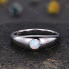 a white opal ring sitting on top of a rock