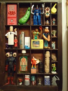 a wooden shelf filled with lots of toy figurines