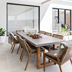 a dining room table and chairs in front of a large glass window with sliding doors