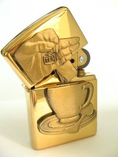 a gold colored lighter with a coffee cup on it