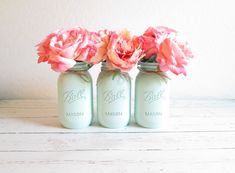 three mason jars with pink flowers in them