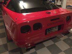 a red sports car sitting on top of a checkered floor