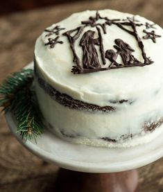 a white cake with chocolate frosting decorated with the word jesus and three people on it