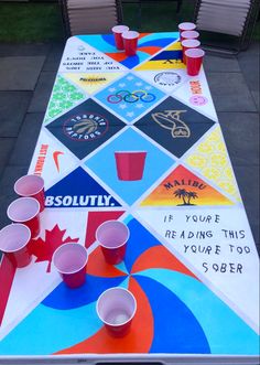 a long table with cups on it that has been designed to look like a board game