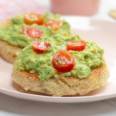 two pieces of bread topped with guacamole and tomatoes