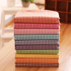 a stack of colorful cloths sitting on top of a wooden table