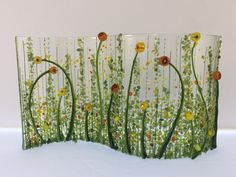 three glass vases sitting on top of a white table covered in flowers and grass