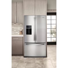 a stainless steel refrigerator in a kitchen with beige cabinets and tile flooring on the walls