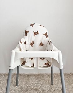 a white high chair with a brown dog print on it