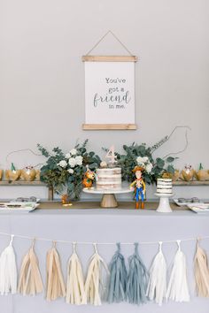 a table topped with cake and tassels next to a sign that says you've got friend in me