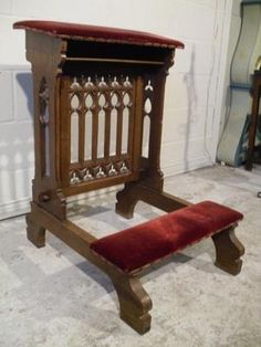 an old wooden bench with a red cushion on it