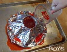 someone is pouring ketchup on top of foil