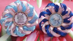 two blue and pink hair clips with an image of a baby on them