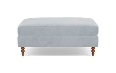 a blue ottoman with wooden legs on a white background