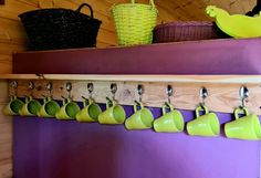 several mugs are hanging from hooks on a shelf