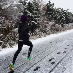 a person running in the snow on a road