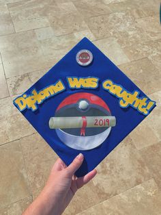 someone is holding up a blue graduation cap