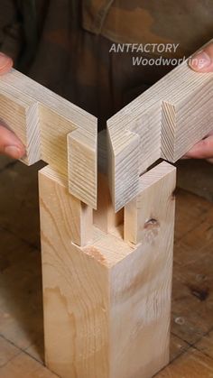 a person is holding some wood with their hands on top of the wooden structure that has been made out of plywood