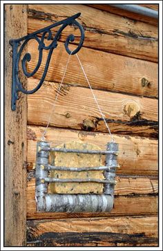 an old fashioned window hanging on the side of a wooden building with metal bars attached to it