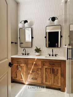 a bathroom with two sinks and mirrors on the wall