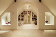 the interior of a home with white walls and vaulted ceilings, built in bookshelves