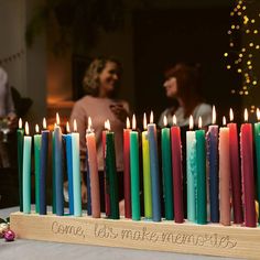 a group of candles sitting on top of a table next to each other with writing on them