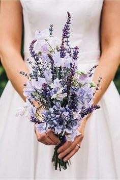 a bride holding a bouquet of flowers in her hands