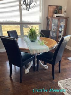 a dining room table with chairs and a potted plant on top of the table