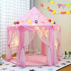 a pink play tent with lights on it