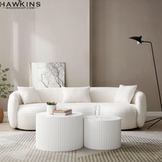 a white couch sitting on top of a rug in a living room next to a lamp