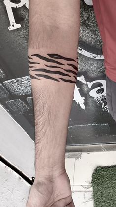 a man with a tattoo on his arm holding onto another person's hand and foot