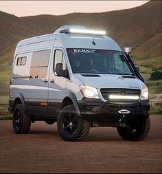 a white van parked on top of a dirt field