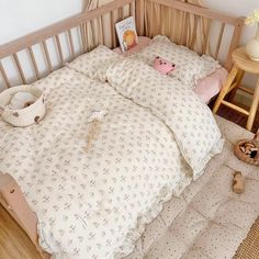 a small child's bed with teddy bears on the pillows and blankets in it