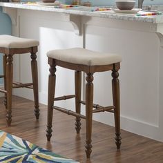 two stools in front of a counter with bowls on it