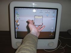 a person's hand is on the screen of a computer