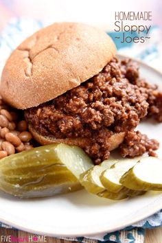 a sloppy joe sandwich on a plate with pickles