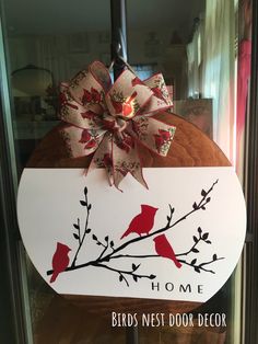 a door hanger with a red bird on it and the words birds nest do or deco