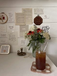 a vase filled with flowers sitting on top of a white counter next to a wall