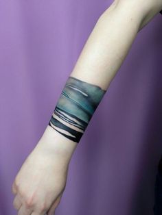 a woman's arm with a wristband that has an abstract design on it