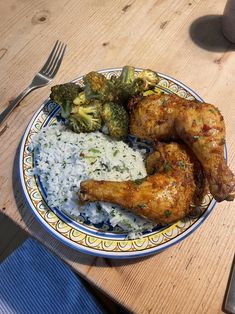 a plate with chicken, rice and broccoli on it next to a fork