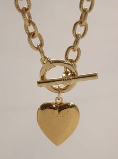 The Heart Locket Toggle Necklace is a firecracker! This women's gold chain is features a diamond cut chain link chain finished with a classic toggle clasp suspending a functional etched heart locket. Length: 16" Available in 24K gold or rhodium plating over steel Patent plating & sealant technology to ensure durability and long lasting wear Made in Los Angeles, CA | Nickel & Lead Free Affordable Nickel-free Chain Necklace For Gifts, Cheap Gold Locket Charm Necklace, Gold Medallion Jewelry With Toggle Clasp, Vintage Gold-tone Jewelry With Toggle Clasp, Yellow Gold Medallion Toggle Necklace Gift, Vintage Gold Heart Necklace With Lobster Clasp, Gold Heart-shaped Necklace With Toggle Clasp, Gold Heart Toggle Necklace With Toggle Clasp, Gold Heart Pendant Toggle Necklace As Gift