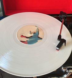 a white record player with a red handle