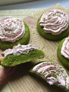 there are green cookies with pink frosting on them