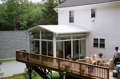 a man is standing on the back deck of a house