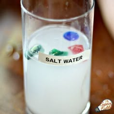 a glass filled with liquid and some writing on the label that says, salt water