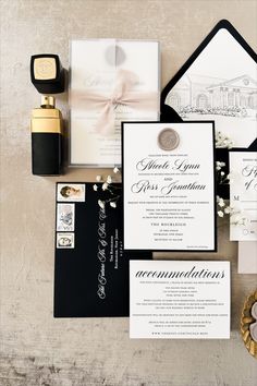 the wedding stationery is laid out with black and white cards, envelopes, and rings